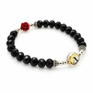 Bracelet semi cristal noir avec une rose et médaille Sainte Rita.